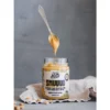 Spoonful of smooth peanut butter above an open Natty Smuuud jar
