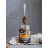 Spoonful of chocolate peanut butter above an open Natty Choco Manolo jar
