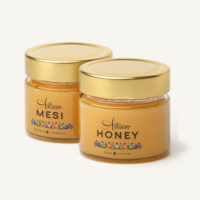 Two jars of Artisan Honey blossom honey with gold lids and Estonian and English labels.